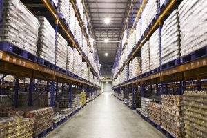 Cans of produce stacked on pallets in warehouse aisle